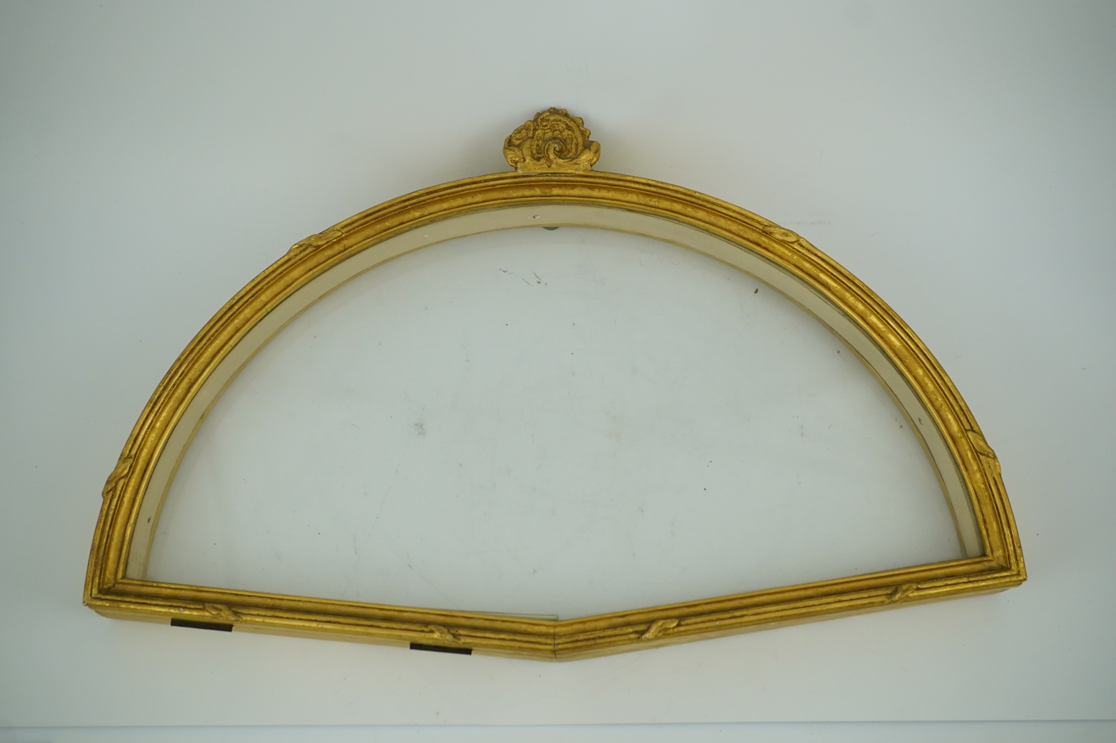Two giltwood fans and display cases, one on a pedestal base housing an 18th century French figural hand painted fan with bone and gilt decorated guards and sticks, the other set with paste gilt metal guards on mother of